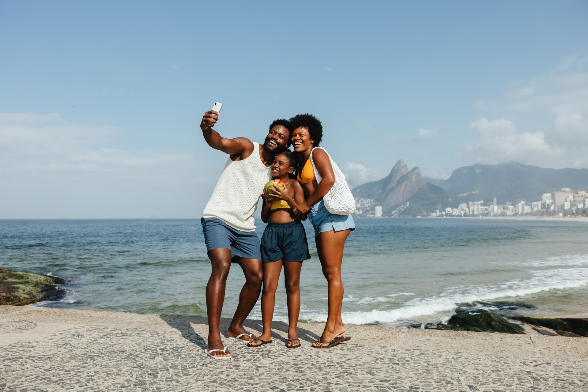 Happy family taking a selfie at Ipanema Beach in Rio de Janeiro